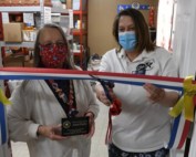 Two women cutting red white and blue ribbon