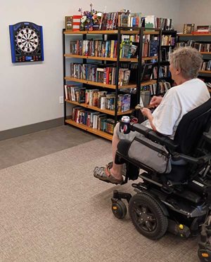 woman in wheelchair throwing dart at board