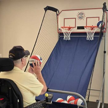 man in wheelchair shooting basketball